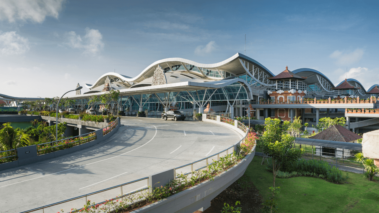 Ngurah Rai International Airport in Bali, Indonesia – main entrance with travelers and signage