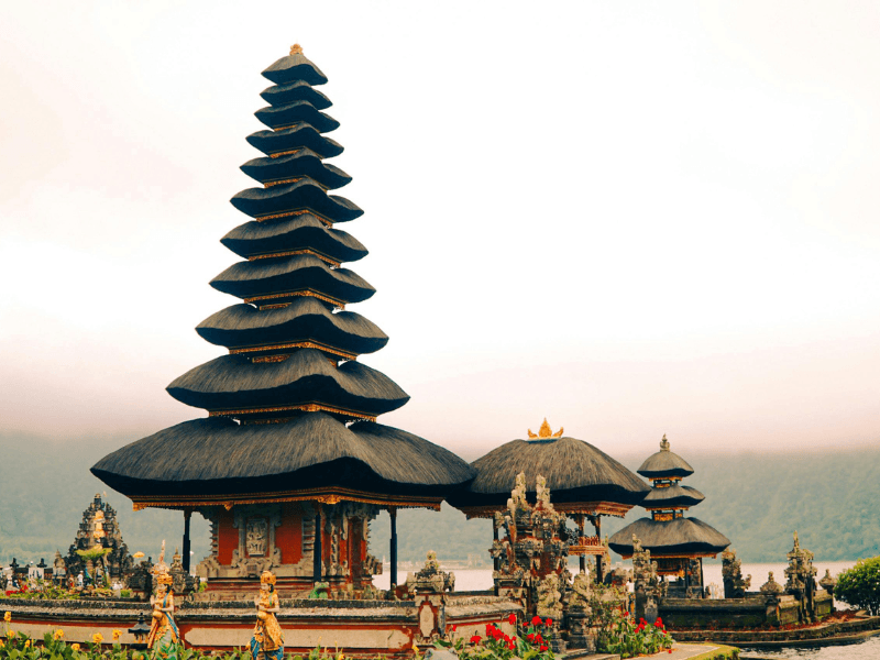 Ulun Danu Beratan Temple in Bedugul, Bali, surrounded by misty mountains and calm lake views.